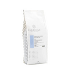 A white bag of Chronicle Coffee Roasters Ketenin Dark Espresso, featuring a clean white design with a light blue label accent and a patterned side panel, set against a plain white background.