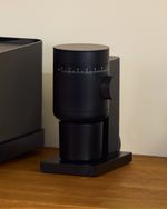 Fellow Opus 2 Black grinder on a wooden coffee counter
